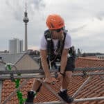 Mitarbeiter auf Gerüst über den Dächern