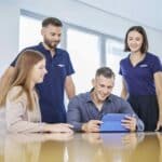 Gruppe arbeitet zusammen auf einem Ipad.