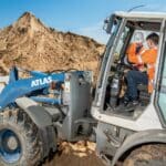 Männer arbeiten mit Radlader auf Baustelle