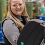 Frau lächelt bei der Arbeit.